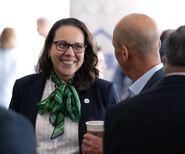 Woman in business attire with green scarf conversing at a LyondellBasell conference